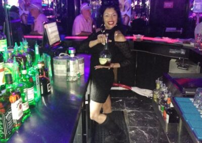 Bartender holing bottle up while posing for the camera